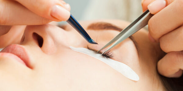 Woman with long eyelashes in a beauty salon during eyelash extension. Beauty concept